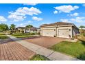 Street view of a single story home with a three car garage and manicured lawn at 3707 Paradiso Cir, Kissimmee, FL 34746