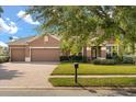 Charming two-story home featuring a three-car garage, lush lawn, and garden at 4822 Lake Milly Dr, Orlando, FL 32839