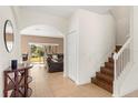 Bright foyer featuring tile floors, staircase, and open archways to living areas at 4822 Lake Milly Dr, Orlando, FL 32839
