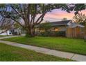 This single-story home features a well-manicured lawn, mature trees, and a charming exterior at 4991 Tangerine Ave, Winter Park, FL 32792