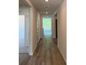 A bright hallway features wood floors and leads to rooms with views of the outdoors at 509 Coronado Cove Rd, New Smyrna Beach, FL 32168