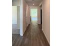 A long hallway leads into a home with wood-look flooring and neutral paint at 511 Coronado Cove Rd, New Smyrna Beach, FL 32168