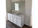 Bathroom featuring a dual sink vanity with ample cabinet space and a large mirror at 512 Coronado Cove Rd, New Smyrna Beach, FL 32168