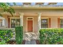 A close-up of the home's front door with columns, hedges, and symmetrical window placement at 6613 Duncaster St, Windermere, FL 34786