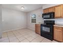 Kitchen area featuring tile floors, wooden cabinets, black microwave and oven at 7906 Arabian Pl, Orlando, FL 32818