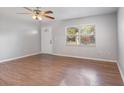 Bright living room with wood-look flooring, large windows, and a ceiling fan at 7906 Arabian Pl, Orlando, FL 32818