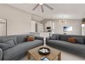 Open living room with modern sofas, a ceiling fan, and an adjacent dining area at 823 Kokomo Cir, Port Orange, FL 32127
