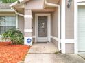 Home's front entry boasts a decorative screen door, ADT security system sign, and manicured landscape at 11512 Grand Bay Blvd, Clermont, FL 34711
