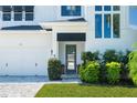 Close up of stylish front door with dark trim and manicured landscaping by the garage at 1312 Vassar St, Orlando, FL 32804