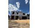Unfinished two-story home showing Tyvek HomeWrap and black framed windows under a bright blue sky at 1402 Stetson St, Orlando, FL 32804