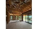 Unfinished living room featuring exposed wood framing, concrete flooring, and a sliding glass door to the backyard at 1402 Stetson St, Orlando, FL 32804