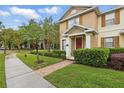 Well maintained home features neat landscaping, brick walkway, and a welcoming red door at 14467 Prunningwood Pl, Winter Garden, FL 34787