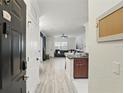 Inviting entryway of condo unit, showcasing the light gray wood floors and a glimpse into the living room at 202 E South St # 5046, Orlando, FL 32801