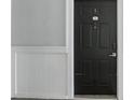 A black front door with a silver handle and a unit number of 5046 on a gray wall at 202 E South St # 5046, Orlando, FL 32801