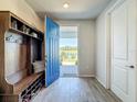 Charming foyer showcasing a blue door, built-in bench, and wood-look tile flooring at 2970 Scout St, St Cloud, FL 34771