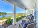 Inviting porch featuring cushioned wicker furniture with a scenic view of the community pond at 2970 Scout St, St Cloud, FL 34771