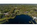 Aerial view of a waterfront acreage bordered in red, showcasing the land's position by a beautiful lake surrounded by lush trees at 372 Carpenter Ave, Osteen, FL 32764