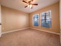 Bright bedroom featuring neutral carpet, a ceiling fan, and two large windows at 4504 Messina Dr, Lake Mary, FL 32746