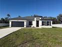 Charming single-Gathering home with a well-manicured lawn, a two-car garage, and a modern architectural style at 489 Marion Oaks Golf Rd, Ocala, FL 34473