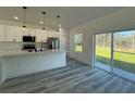 Open kitchen with white cabinetry, stainless steel appliances, and large sliding glass doors at 489 Marion Oaks Golf Rd, Ocala, FL 34473