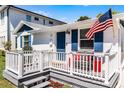 Welcoming front porch with gray deck and stairs, white railing, American flag, and outdoor seating at 515 Clayton St, Orlando, FL 32804