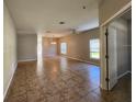 Open-concept living area with tile flooring, ceiling fan, and abundant natural light from many windows at 5342 Rabbit Ridge Trl, Orlando, FL 32818