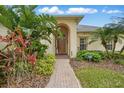 Inviting front entrance with brick walkway, well-maintained landscaping, and a covered arched entryway at 548 Burford Cir, Davenport, FL 33896