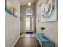Inviting home foyer with a front door with sidelights, a bench, and decorative artwork at 611 Saddle Ridge Dr, Davenport, FL 33896