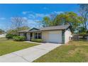 Well-kept single-story home featuring an attached garage and a long driveway at 913 Jacaranda Dr, Lady Lake, FL 32159