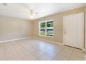 Bright living room with neutral walls, tiled floors, a ceiling fan, and a large window at 913 Jacaranda Dr, Lady Lake, FL 32159