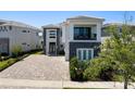 Two-story home showing modern architectural details, well-maintained landscaping, and a brick driveway at 942 Jack Nicklaus Ct, Kissimmee, FL 34747