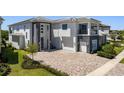 Beautiful two-story home featuring a modern facade, manicured landscaping, and a spacious brick driveway at 942 Jack Nicklaus Ct, Kissimmee, FL 34747