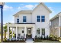 Inviting two-story home with covered front porch, rocking chairs, and a beautifully landscaped entrance at 1118 Eagles Pass Way, Winter Garden, FL 34787