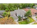 Aerial view of a home with a lush landscaped yard, mature trees, and a well-maintained gray roof at 13325 Falcon Pointe Dr, Orlando, FL 32837