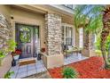 Inviting front porch with stone pillars, decorative wreath, and a cozy seating area at 13812 Magnolia Glen Cir, Orlando, FL 32828