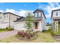 Beautiful home featuring a two-car garage, stylish blue accents, and a well-maintained front yard with greenery at 2313 Mystic Maze Ln, Clermont, FL 34715