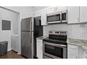 Bright kitchen featuring stainless steel appliances, white subway tile backsplash, and granite countertops at 2717 Maitland Crossing Way # 205, Orlando, FL 32810