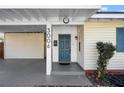 A close up of the front door, shows the house number, covered parking, and clean well kept yard at 3006 Northwood Blvd, Winter Park, FL 32789