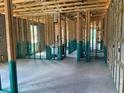 Open-concept layout featuring concrete flooring, wooden framing, and plumbed walls in new construction at 3027 Turkey Ave, Oviedo, FL 32765