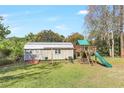 A backyard featuring storage shed, swing set, and slide, ideal for outdoor activities and storage at 323 Marjorie Blvd, Longwood, FL 32750