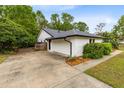 Side view of the home showing a two-car garage and a concrete driveway at 3553 Jericho Dr, Casselberry, FL 32707