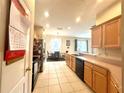 Functional kitchen with wood cabinets and ample counter space flowing into the adjacent dining area at 3810 Blue Dasher Dr, Kissimmee, FL 34744