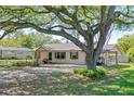 Cozy single-story home with attached carport, green shutters, and large shade tree at 412 N Boyd St, Winter Garden, FL 34787