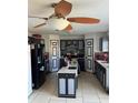 Functional kitchen with an island, tile floor, and black appliances, perfect for cooking and entertaining at 428 Ohio Ln, Kissimmee, FL 34759