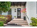 Elegant entryway with a brick staircase leading to a stylish door with dark shutters and colorful landscaping at 4457 Anson Ln, Orlando, FL 32814