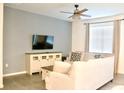 Bright living room featuring a modern ceiling fan, stylish furniture, and neutral color palette at 4489 Monado Dr, Kissimmee, FL 34746