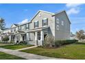 Well-kept townhome featuring a cozy front porch and manicured lawn at 502 Rainbow Springs Loop, Groveland, FL 34736