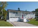 Charming home exterior featuring an attached garage, solar panels, manicured lawn, and a red front door at 504 Teakwood Dr, Altamonte Springs, FL 32714