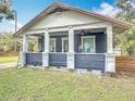 A covered front porch featuring white pillars and an overhead ceiling fan at 505 E Plymouth Ave, Deland, FL 32724