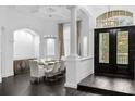 A bright dining room features a glass table, seating for eight, dark wood floors, and an elegant chandelier at 6030 Greatwater Dr, Windermere, FL 34786